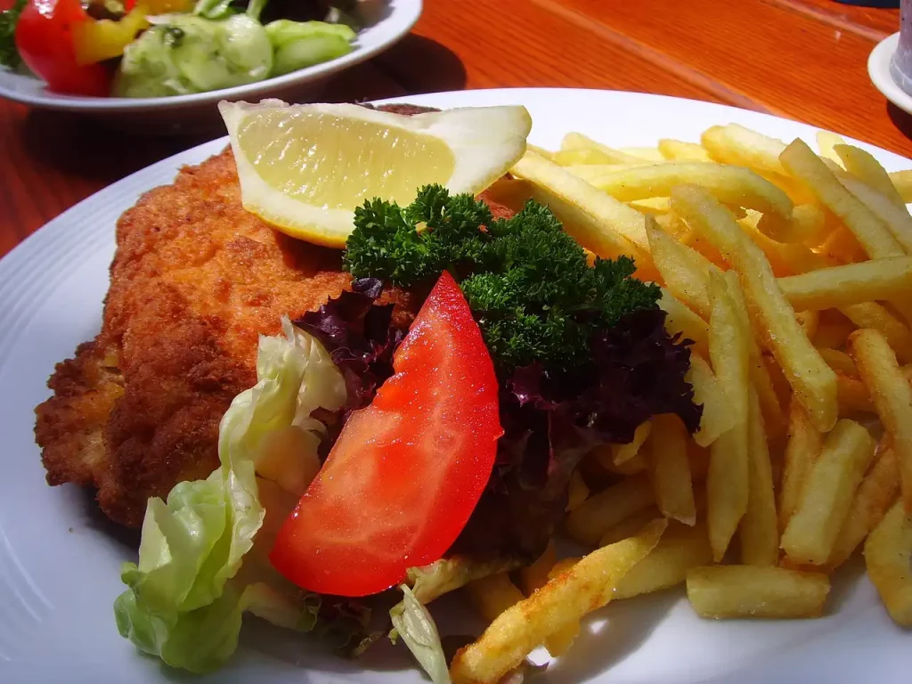 Teller mit Schnitzel und Pommes und Salatdeko